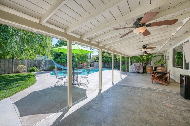 view of swimming pool with a fenced backyard, a ceiling fan, a patio area, and a water slide