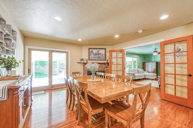 dining area featuring light wood-type flooring, recessed lighting, a textured ceiling, french doors, and a ceiling fan