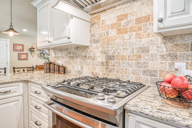 kitchen featuring white cabinets, light stone counters, stove, and tasteful backsplash
