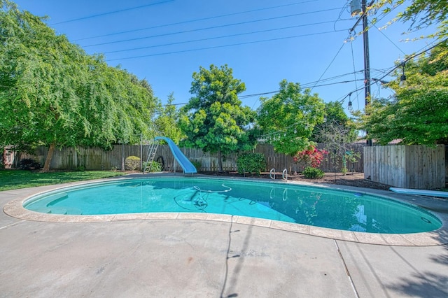 view of swimming pool featuring a fenced in pool, a fenced backyard, a diving board, and a water slide