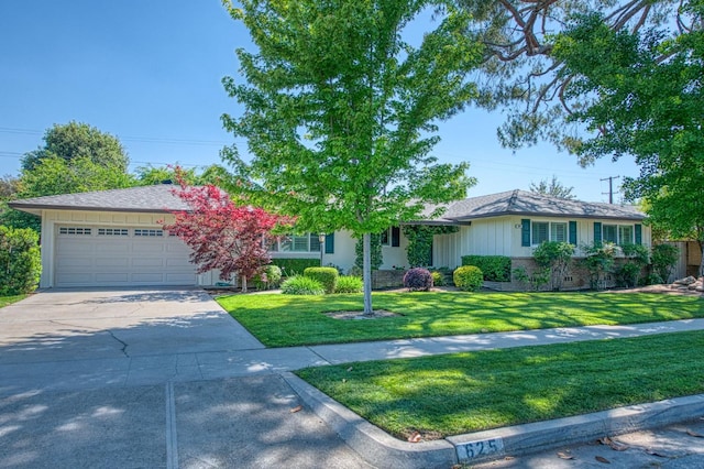 single story home with a garage, concrete driveway, and a front lawn