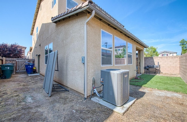 rear view of house with central air condition unit, a patio, a fenced backyard, and stucco siding