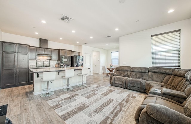 living area with recessed lighting, light wood-type flooring, and visible vents