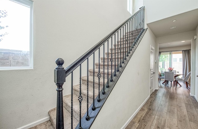 stairs featuring recessed lighting, baseboards, and wood finished floors