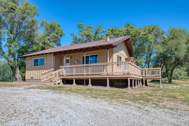view of front of home featuring a deck and a shingled roof