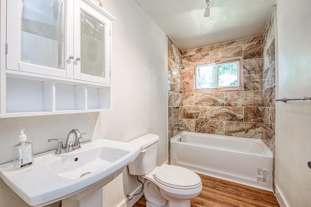 bathroom with a sink, wood finished floors, bathing tub / shower combination, and toilet