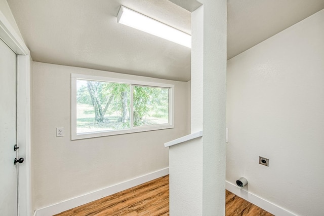 clothes washing area featuring baseboards, hookup for an electric dryer, laundry area, and wood finished floors