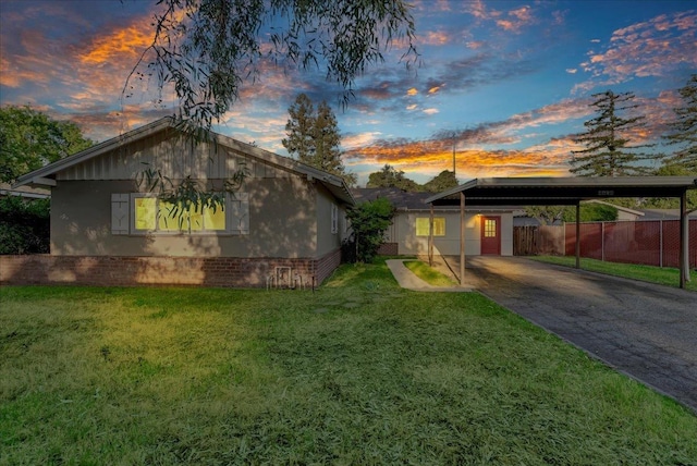 view of front of house with an attached carport, fence, driveway, and a front lawn