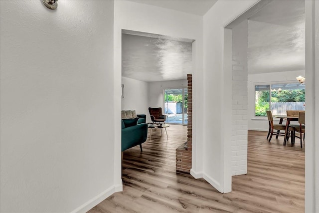 corridor with baseboards and wood finished floors
