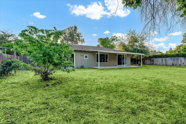 back of house featuring a fenced backyard, a patio, stucco siding, and a yard