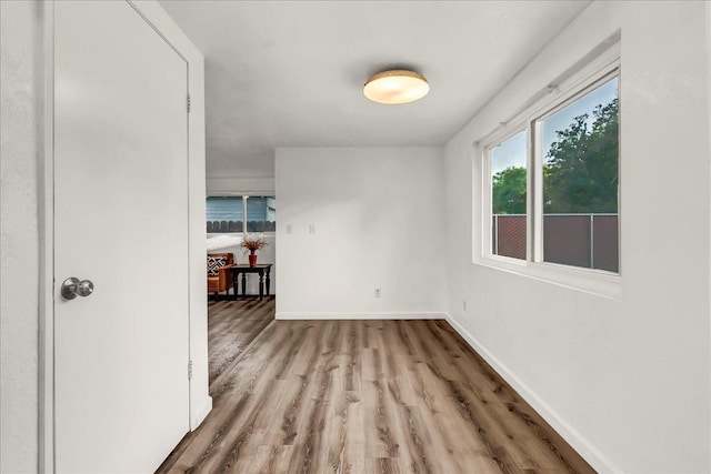 unfurnished room with baseboards and wood finished floors