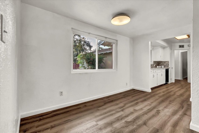 unfurnished living room with baseboards, wood finished floors, and visible vents