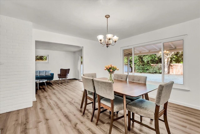 dining room with light wood-style floors, baseboards, and an inviting chandelier