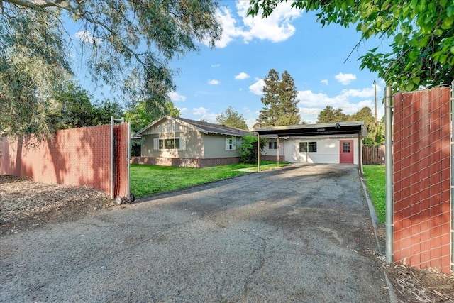 view of front of property with a front lawn, fence, driveway, and a carport