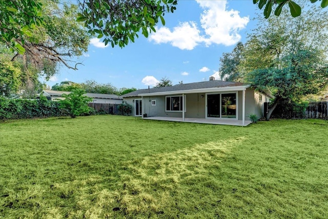 rear view of property featuring a patio, a fenced backyard, stucco siding, and a yard