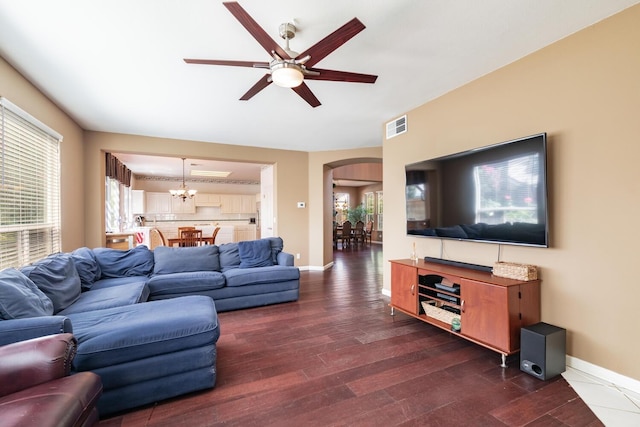 living room featuring visible vents, wood finished floors, baseboards, arched walkways, and ceiling fan with notable chandelier