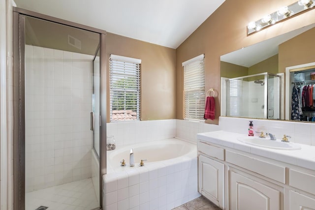 full bathroom with a bath, tile patterned flooring, a stall shower, vanity, and lofted ceiling