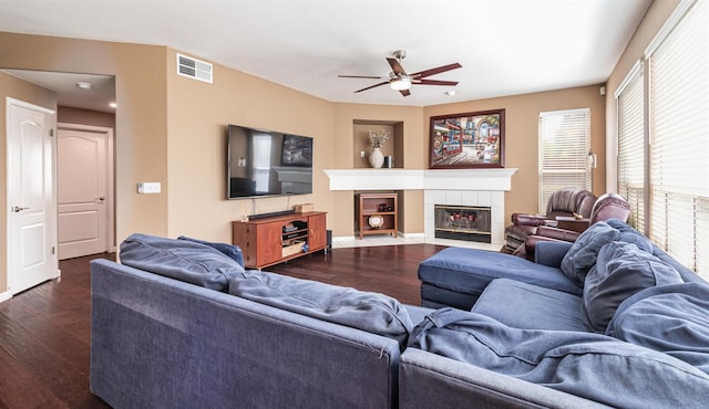 living area with a ceiling fan, visible vents, dark wood-style floors, and a fireplace