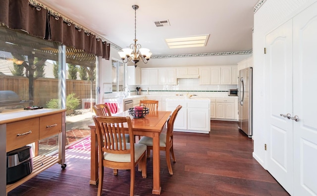 dining area featuring a notable chandelier, dark wood-style flooring, and visible vents