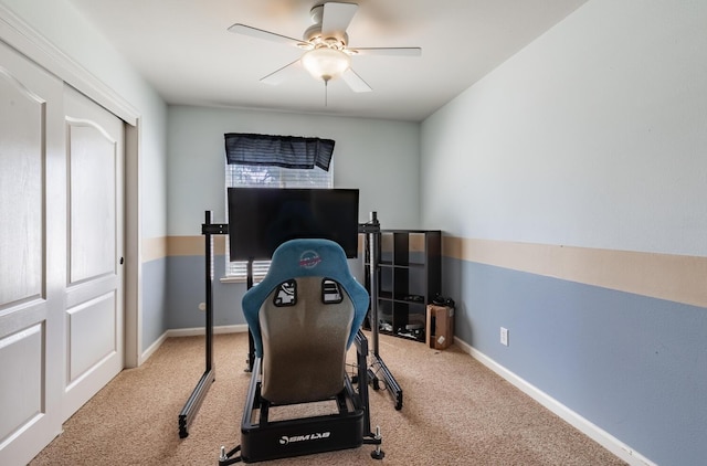 exercise area with ceiling fan, baseboards, and carpet
