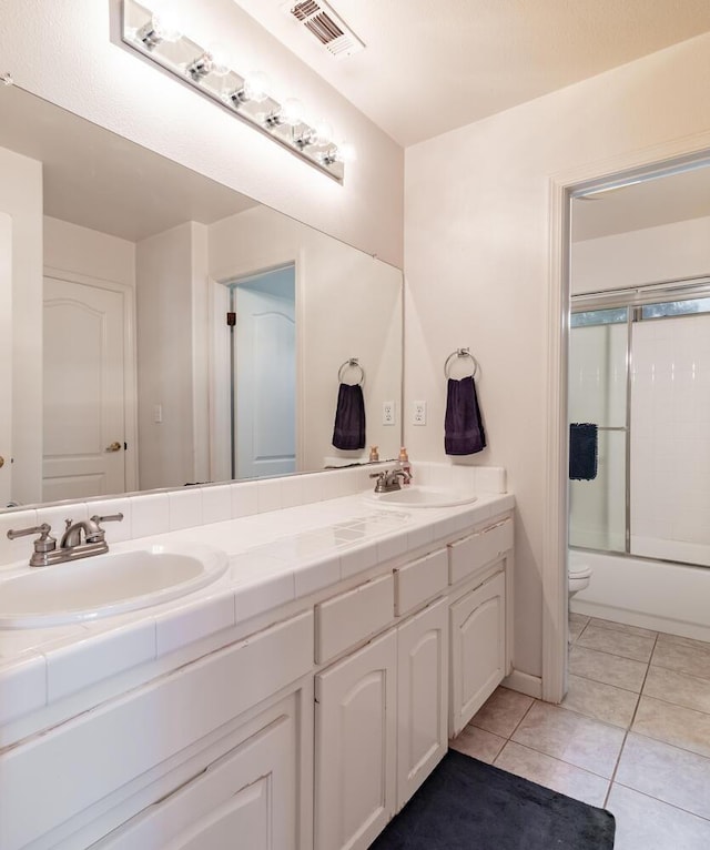 full bathroom featuring double vanity, tile patterned floors, visible vents, and a sink