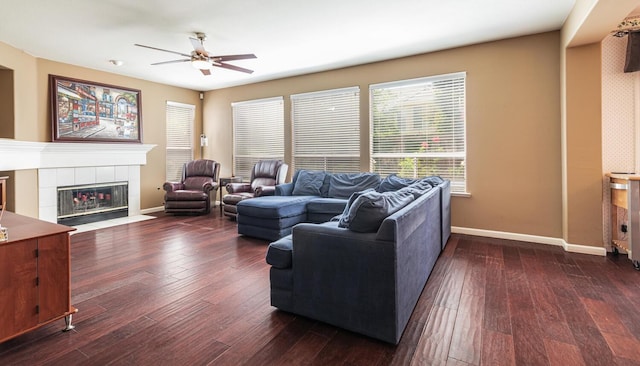 living room with a ceiling fan, baseboards, and dark wood-style floors