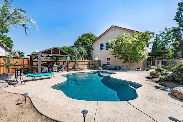 view of pool featuring a fenced backyard, a fenced in pool, a patio, and a gazebo