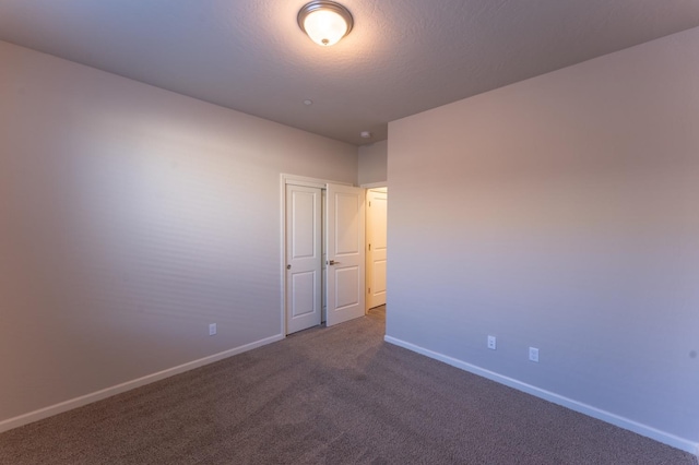 empty room with baseboards and carpet