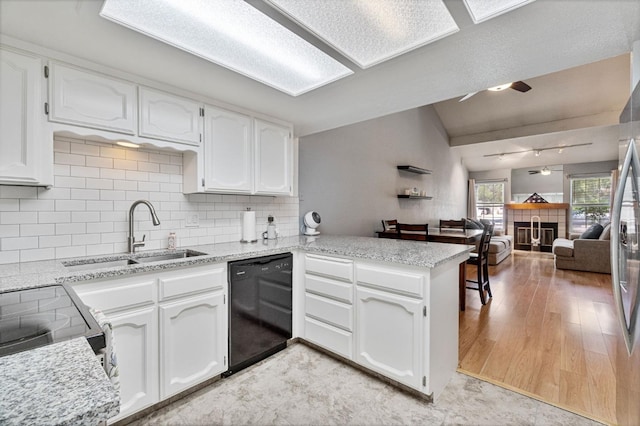 kitchen with a sink, a peninsula, lofted ceiling, a ceiling fan, and dishwasher