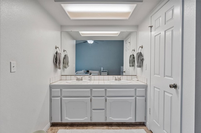 full bathroom featuring double vanity, a sink, and ceiling fan