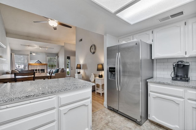 kitchen with ceiling fan, decorative backsplash, visible vents, stainless steel fridge with ice dispenser, and white cabinetry