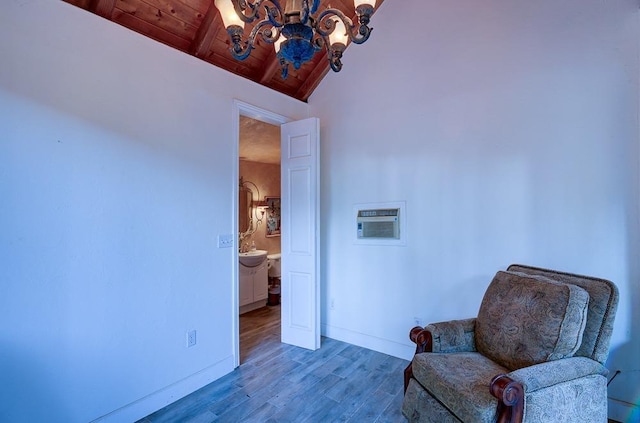 sitting room with an inviting chandelier, baseboards, wood finished floors, and wooden ceiling