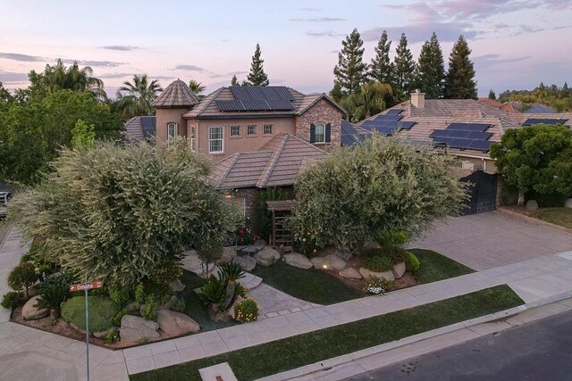71 Omaha Ave, Clovis, CA 93619 - view of front of home featuring a tile roof, solar panels, decorative driveway, stucco siding, and a garage