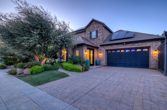 71 Omaha Ave, Clovis, CA 93619 - view of front of property with stone siding, a garage, solar panels, and driveway