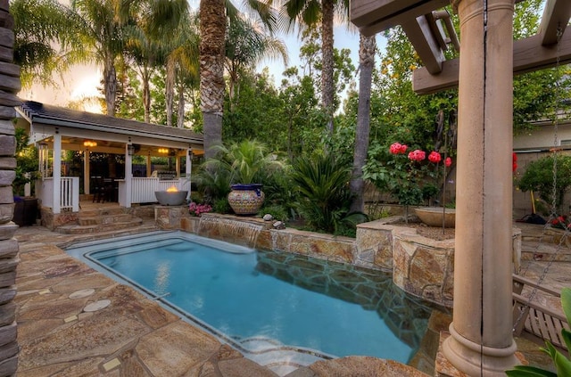pool at dusk with a fenced in pool, fence, and a patio