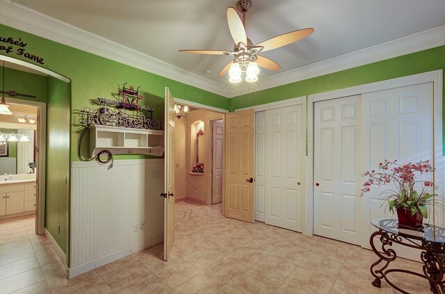 71 Omaha Ave, Clovis, CA 93619 - bedroom with two closets, ornamental molding, light tile patterned floors, ceiling fan, and ensuite bathroom