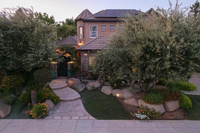 71 Omaha Ave, Clovis, CA 93619 - view of front of property featuring roof mounted solar panels, stone siding, and a tiled roof