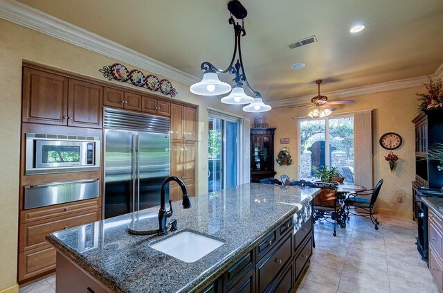 71 Omaha Ave, Clovis, CA 93619 - kitchen with built in appliances, a warming drawer, a sink, crown molding, and dark stone countertops
