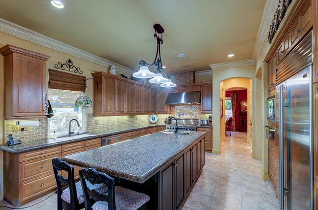 71 Omaha Ave, Clovis, CA 93619 - kitchen with arched walkways, under cabinet range hood, a sink, stainless steel appliances, and ornamental molding