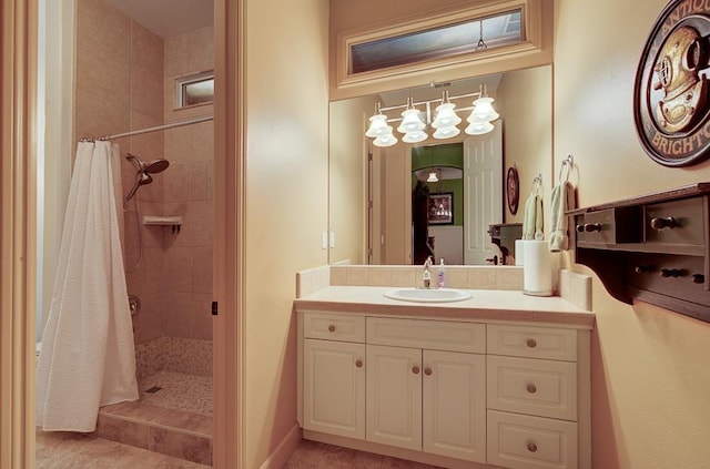 full bathroom with tile patterned floors, tiled shower, and vanity