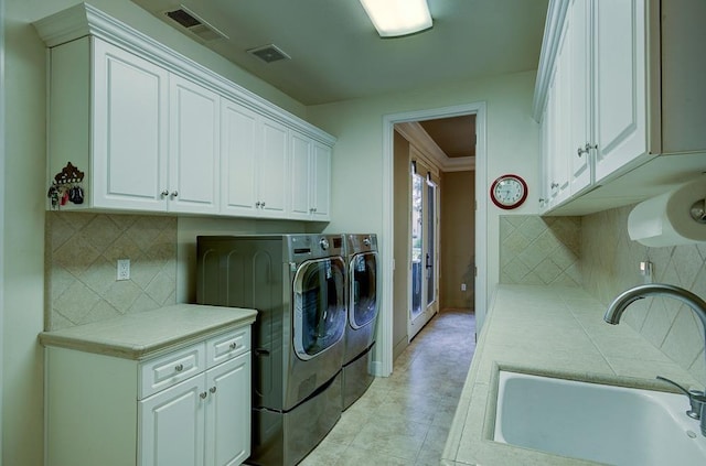 71 Omaha Ave, Clovis, CA 93619 - washroom with washing machine and clothes dryer, cabinet space, baseboards, ornamental molding, and light tile patterned floors