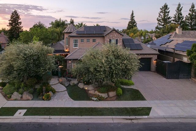 71 Omaha Ave, Clovis, CA 93619 - view of front of home with solar panels, a tile roof, stone siding, driveway, and a garage
