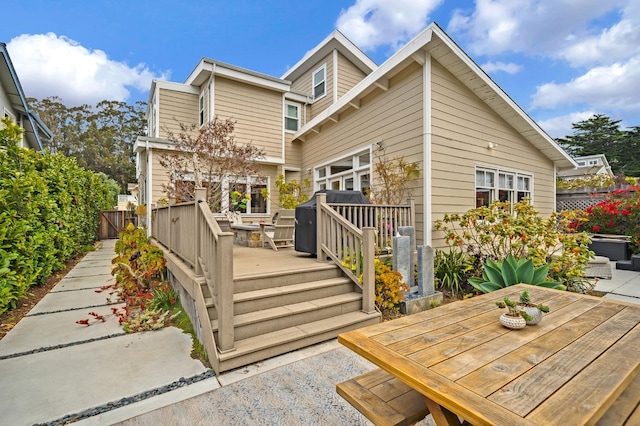 rear view of house with outdoor dining space and a deck