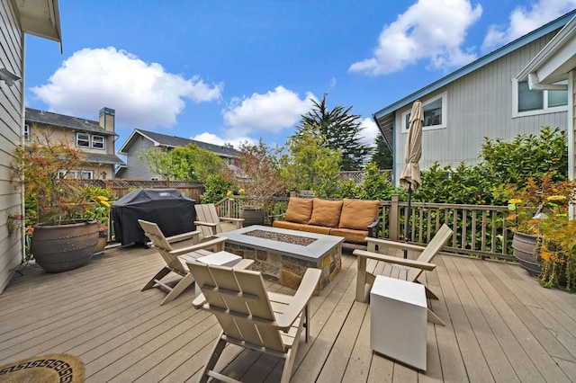 wooden deck featuring grilling area, fence, and an outdoor fire pit