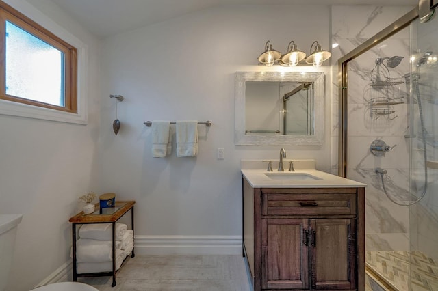 bathroom featuring a marble finish shower, baseboards, vanity, and toilet