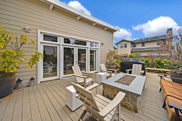wooden deck with a grill, french doors, and an outdoor fire pit
