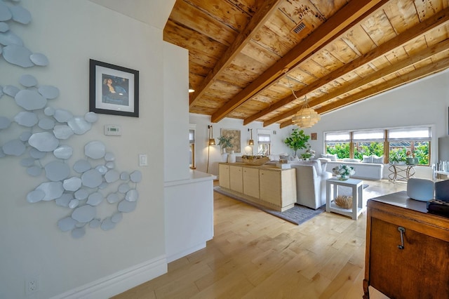 kitchen with hanging light fixtures, lofted ceiling with beams, an inviting chandelier, light wood finished floors, and wood ceiling