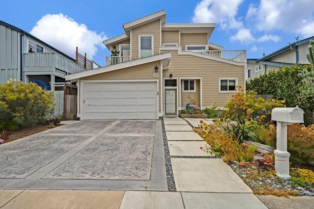 view of front of house featuring an attached garage, a balcony, and concrete driveway
