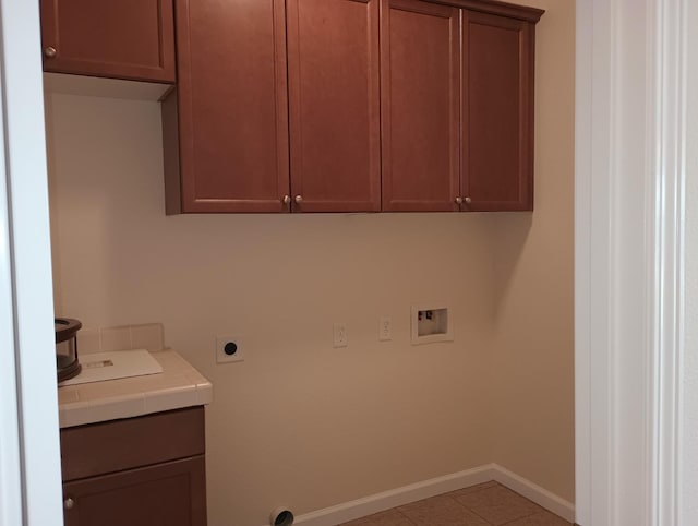 laundry room featuring cabinet space, tile patterned flooring, hookup for a washing machine, baseboards, and hookup for an electric dryer