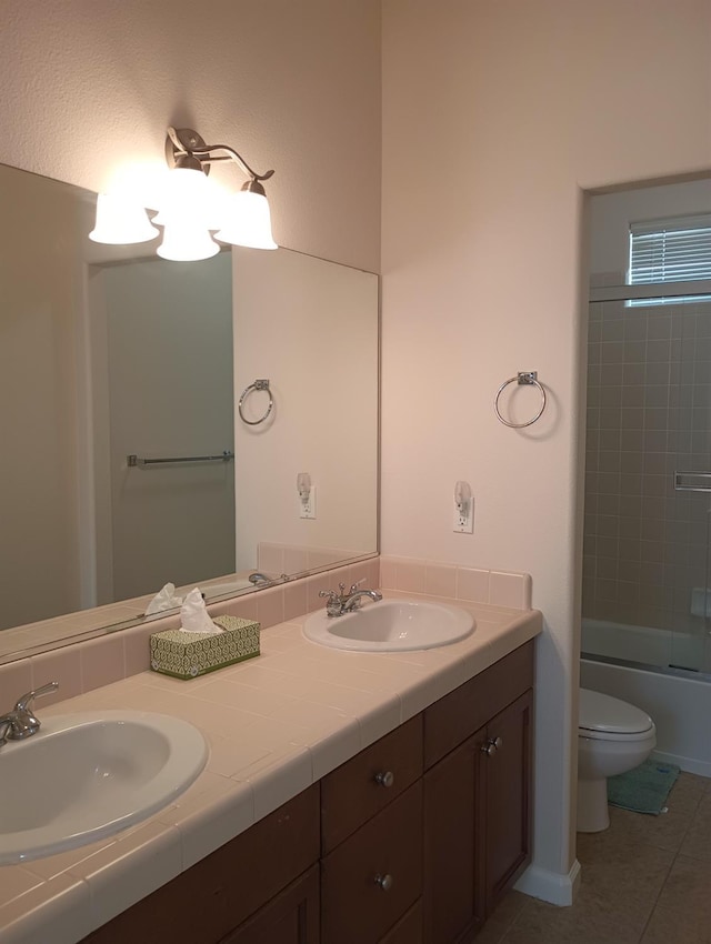 full bathroom featuring a sink, tile patterned flooring, toilet, and double vanity